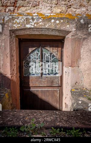 Hunawihr, Frankreich - 09 04 2023: Blick auf die Tür mit Buntglas eines typischen rosa Hauses Stockfoto