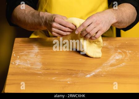 Junger attraktiver Koch Koch indischer Naan auf gelbem Hintergrund Stockfoto