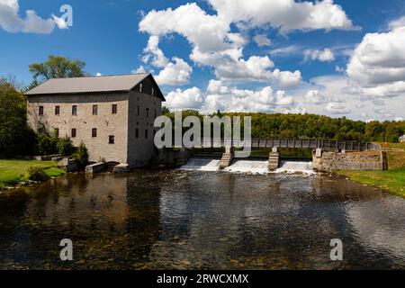 Lang Grist Mill und Brücke über den Wasserfalldamm im Pioneer Village am Indian River Keene Ontario Kanada. Stockfoto