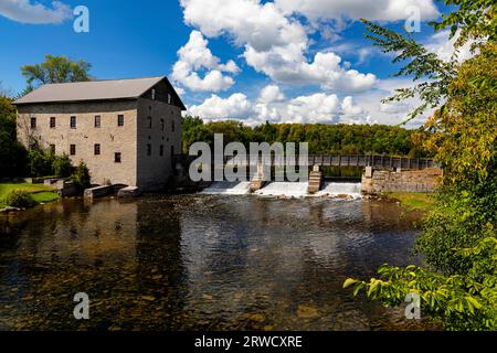 Lang Grist Mill und Brücke über den Wasserfalldamm im Pioneer Village am Indian River Keene Ontario Kanada. Stockfoto