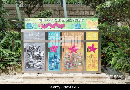 Recyclingbehälter für Papier, Kunststoffe und Metall im Central Park von Hongkong, umgeben von Pflanzen. Hongkong - 31. August 2023 Stockfoto