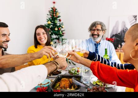 Glückliche Familie feiert weihnachten mit Wein zu Hause Stockfoto