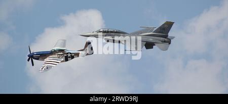 Heritage Flight: F-16 und P-51 Mustang Soar Against Blue Skies bei NAS Pensacola Stockfoto