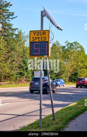 Schildern Sie auf einer befahrenen Straße, die den Fahrern ihre Geschwindigkeit anzeigt, um zu verhindern, dass sie zu schnell fahren. Stockfoto