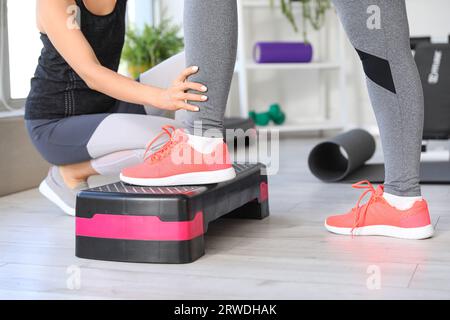 Reife Frauentraining mit Stepper und Therapeutin im Rehabilitationszentrum, Nahaufnahme Stockfoto