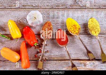 Holztisch mit Auswahl an gemahlenen Gewürzen in kleinen Löffeln Stockfoto