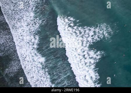 Atemberaubende Luftaufnahme von oben nach unten der Wellen brechen auf tropischem Meer Surfer mit Surfbrettern Luftdrohnenaufnahme der Meereswellen auf der wunderschönen Meeresoberfläche oc Stockfoto