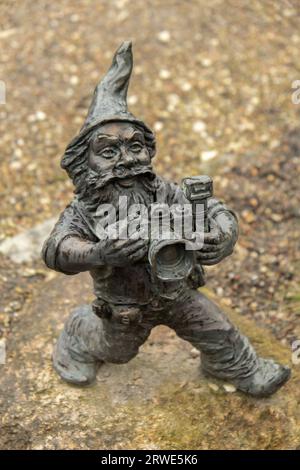 Zwerg mit Kamera - Fotograf. Kleine Bronzefiguren von Gnomen auf den Straßen von Breslau. Europa Miniaturbronze-Figur eines Gnoms. Symbol von Breslau. Touristenattraktion Stockfoto