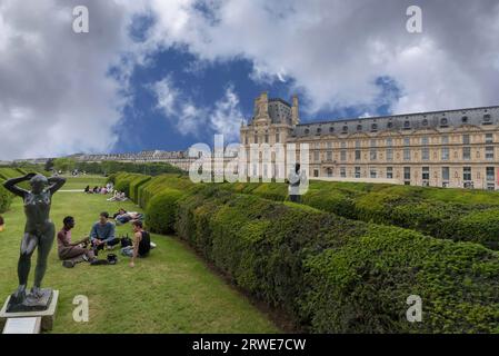 Junge Menschen auf den Grünflächen vor dem Louvre, Paris, Frankreich Stockfoto