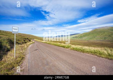 Die einspurige Straße und Touristenroute oder die malerische Straße North Coast 500, auch NC500 genannt, mit einem Passplatz für entgegenkommenden Verkehr, ausgestattet mit einem Stockfoto