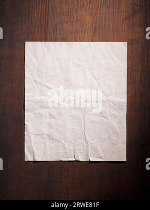 Altes faltiges leeres Papier auf hölzernem Hintergrund Stockfoto