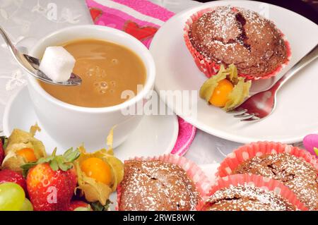 Kaffee mit Milch und Zucker mit einem Muffin Stockfoto