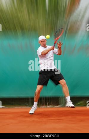 Tennisspieler trifft Topspin vor dem Spiel Stockfoto