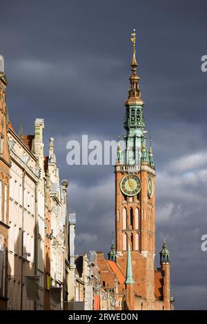 Rathaus (Polnisch: Ratusz Glownego Miasta) Uhrturm in der Altstadt von Danzig in Polen, in Sonnenlicht gebadet, kurz vor dem Sturm Stockfoto