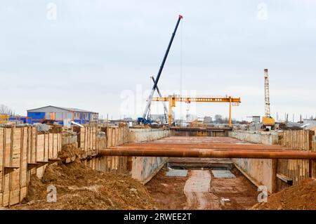 Ein riesiger Gräben-Tunnel mit Verstärkungsstrukturen aus dicken Eisenrohren und Bauten auf der Baustelle des unterirdischen Me Stockfoto