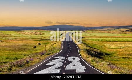 Neujahrskonzept 2024. Text 2024 auf der Straße in der Mitte der Asphaltstraße geschrieben. Stockfoto