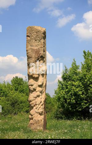 Künstlerskulptur auf der Friedensstraße in Wellingen bei Merzig im Saarland, Hintergrundlandschaft und blau-weißer Himmel Stockfoto