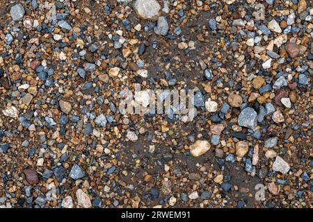 Graue, kleine Felsen, Grundstruktur. Schwarzer, kleiner Straßensteinhintergrund. Kieselsteine Steinstruktur Stockfoto