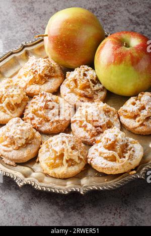 Süße Apfelstreusel-Shortbread-Kekse, bestreut mit Puderzucker, auf einem Teller auf dem Tisch. Vertikal Stockfoto