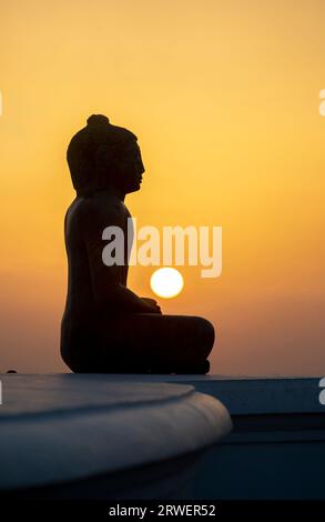 Die Sonne untergeht über der Maha Seya (Stupa) und Buddha Statue in Mihinthale in Sri Lanka. Die antike Stätte stammt aus dem Jahr 250 v. Chr. Stockfoto