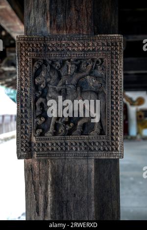 Eine alte Schnitzerei, die einen Mann zeigt, der auf einem Pferd reitet und sich auf einer der Holzsäulen im Grabpavillon der Embekke Devale in Sri Lanka befindet Stockfoto