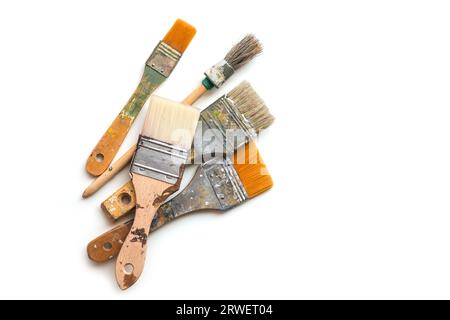 Vier gebrauchte Pinsel für Farbe, Lack, Lack und Beize isoliert mit Schatten auf weißem Hintergrund, Kopierraum, Draufsicht von oben, ausgewählter Fokus Stockfoto