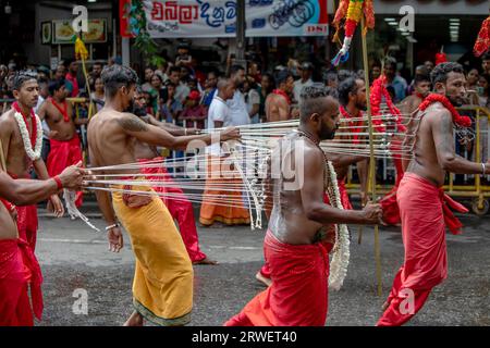 Kavadi-Tänzerinnen (Hindu) mit zahlreichen Hakenkörper-Piercings treten während des Tages Perahera auf einer Straße von Kandy in Sri Lanka auf. Stockfoto