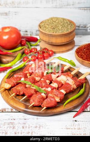 Rinderfilet-Spieß auf Holzuntergrund. Rinderfilet-Spieß mit roher Sauce mit Kräutern und Gewürzen Stockfoto