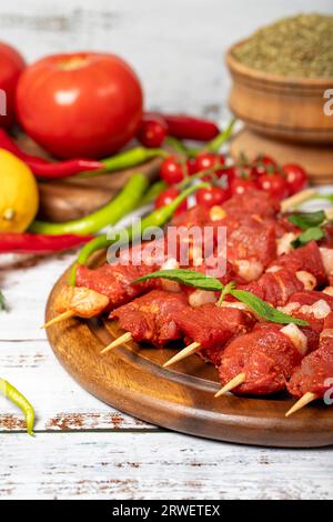 Rinderfilet-Spieß auf Holzuntergrund. Rinderfilet-Spieß mit roher Sauce mit Kräutern und Gewürzen. Nahaufnahme Stockfoto