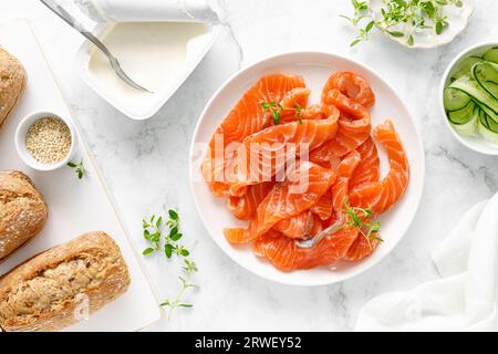Gesalzener Lachs auf Platte auf weißem Hintergrund, Ansicht von oben nach unten Stockfoto