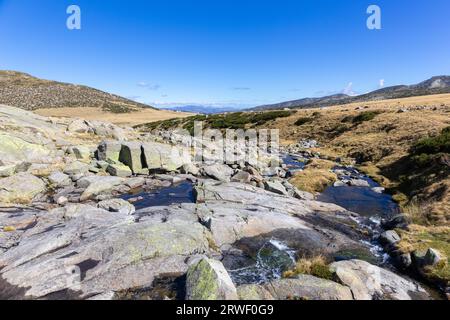 Steine und wilder Fluss auf Wanderweg zum Laguna Grande de Gredos See von der Plataforma de Gredos in der Sierra de Gredos, Spanien. Stockfoto