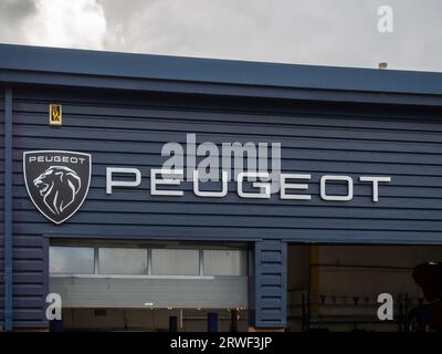 Schild und Logo von Peugeot Cars, Autohändler von Bristol Street Motors, Riverside Retail Park, Northampton, Großbritannien Stockfoto