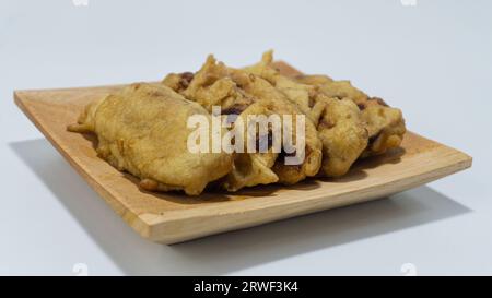 Pisang Goreng oder gebratene Bananen serviert auf einem Holzteller isoliert auf weißem Hintergrund Stockfoto