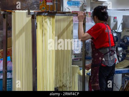 Taiwanesische Leute hängen Reisnudeln in einem Geschäft, New Taipei, Tamsui, Taiwan Stockfoto