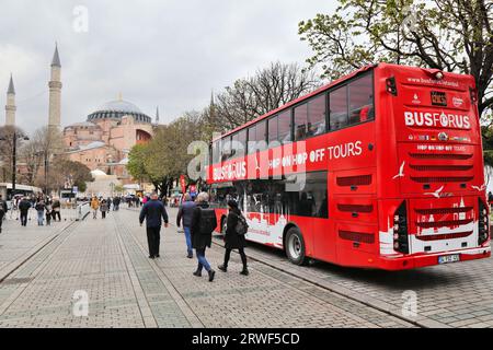 ISTANBUL, TÜRKEI - 11. APRIL 2023: Touristen fahren Hop-on-Hop-off-Bustour in der Nähe der Hagia Sophia Moschee in Istanbul, Türkei. Stockfoto