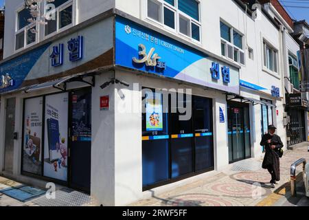 CHANGWON, SÜDKOREA - 28. MÄRZ 2023: People Walk by Jihae Credit Union in Jinhae, Changwon. Sie ist Teil der National Credit Union Federation of Korea Stockfoto