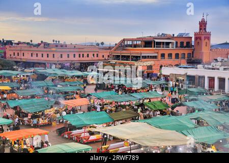 MARRAKESCH, MAROKKO - 20. FEBRUAR 2022: Besucher besuchen den Jemaa el-Fnaa (Djemaa el Fna)-Markt in Marrakesch. Der Platz ist zum UNESCO-Weltkulturerbe ernannt Stockfoto