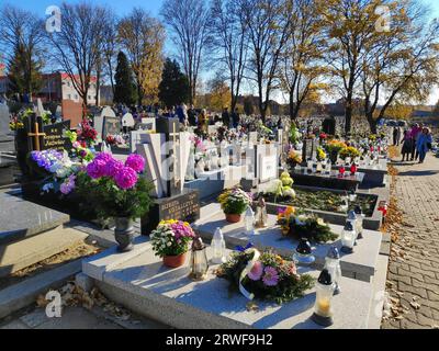 BYTOM, POLEN - 1. NOVEMBER 2021: Menschen besuchen die Gräber auf einem Friedhof am Allerheiligen-Tag (Wszystkich Swietych) in Polen. Stockfoto