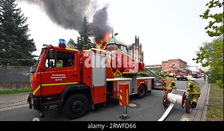 Nordhausen, Deutschland. September 2023. PRODUKTION - 19. September 2023, Thüringen, Nordhausen: Die Dachkonstruktion eines Gebäudes brennt in der Rothenburgstraße in Nordhausen. Die Feuerwehr versucht, das Feuer zu löschen. Foto: Martin Schutt/dpa Credit: dpa Picture Alliance/Alamy Live News Stockfoto