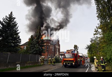 Nordhausen, Deutschland. September 2023. PRODUKTION - 19. September 2023, Thüringen, Nordhausen: Die Dachkonstruktion eines Gebäudes brennt in der Rothenburgstraße in Nordhausen. Die Feuerwehr versucht, das Feuer zu löschen. Foto: Martin Schutt/dpa Credit: dpa Picture Alliance/Alamy Live News Stockfoto