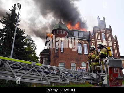 Nordhausen, Deutschland. September 2023. PRODUKTION - 19. September 2023, Thüringen, Nordhausen: Die Dachkonstruktion eines Gebäudes brennt in der Rothenburgstraße in Nordhausen. Die Feuerwehr versucht, das Feuer zu löschen. Foto: Martin Schutt/dpa Credit: dpa Picture Alliance/Alamy Live News Stockfoto