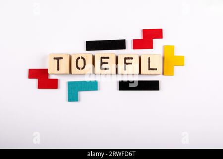 TOEFL. Wort aus Holzalphabetensteinen auf weißem Hintergrund. Stockfoto