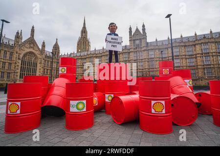 London UK. 19 . September 2023 . Ein Modell mit einem riesigen Kopf von Premierminister Rishi Sunak auf BP- und Shell-Ölfässern während eines Oxfam-Protestes vor dem Parlament als Teil der Kampagne Make Polluters Pay, Oxfam fordert Öl- und Gasriesen stärker zu besteuern, um Gemeinden, die vom Klimawandel betroffen sind, zu unterstützen. Credit amer ghazzal/Alamy Live News Stockfoto