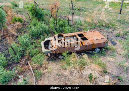Draufsicht auf ein zerstörtes gepanzertes Kampffahrzeug auf dem Land nach einer Schlacht. Krieg in der Ukraine. Russische Invasion der Ukraine Stockfoto