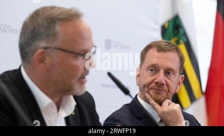 Freiberg, Deutschland. September 2023. Dirk Neubauer (Independent, l), Landrat des Landkreises Mittelsachsen, und Michael Kretschmer (CDU), Ministerpräsident von Sachsen, sprechen auf der Pressekonferenz nach der Kabinettssitzung in Freiberg. Ein Thema war die Beteiligung der Bürger und der Gemeinschaft am Bau und Betrieb von Windkraftanlagen. Außerdem wurden Pläne für den Nachhaltigkeitscampus Freiberg/Mittelsachsen am Helmholtz-Institut Freiberg vorgestellt. Quelle: Hendrik Schmidt/dpa/Alamy Live News Stockfoto