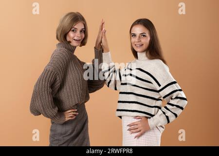 Zwei junge Freundinnen geben High Five Hold Hands Stockfoto