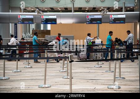 31.07.2023, Singapur, Republik Singapur, Asien - Flugreisende geben ihr Gepäck an einem Check-in-Schalter für Biman Bangladesh Airlines bei Sing auf Stockfoto