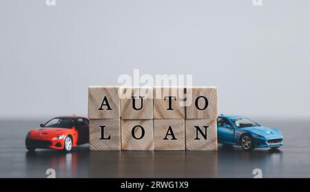 Das Wort AUTO LOAN in englischer Sprache, geschrieben auf Holzwürfeln. Finanzierung und Autokredit, Refinanzierung, Investition und Geschäftskonzept mit Kopierraum. Stockfoto