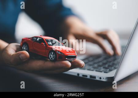 Auto in der Hand und eine Fernbedienung für schlüssellosen Zugang. Autokredit, Vertragsvereinbarung, Kauf- und Mietwagenkonzept, Verkaufsmitarbeiter, der das Fahrzeug zur Hand hält. Stockfoto