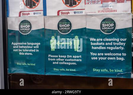 Slough, Berkshire, Großbritannien. September 2023. Ein verblasstes soziales COVID-19-Distanzschild in einem Schaufenster in Slough, Berkshire. Menschen ab 65 Jahren werden dringend aufgefordert, ihre COVID-19-Booster-Jabs für den Herbst zu besorgen, da die Fälle im gesamten Vereinigten Königreich weiter zunehmen. Die Einführung der Herbstimpfungen wurde als Vorsichtsmaßnahme gegen eine hochgradig mutierte neue COVID-Variante namens BA.2,86 vorgezogen. Viele Menschen, die unter 65 Jahre alt sind, befürchten, dass sie nicht mehr für eine COVID-19-Auffrischungsimpfung oder eine Grippeschutzimpfung in Frage kommen, da die Regierung offenbar die Kosten senkt. Kredit: Maureen McLean/Alamy Stockfoto